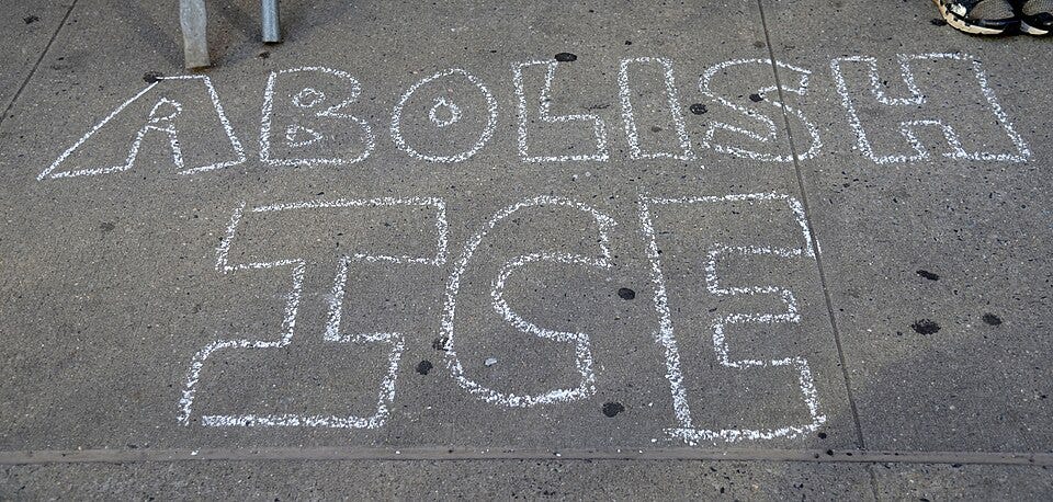 Sidewalk chalk drawing that reads Abolish ICE in bubble letters. Sidewalk chalk drawing that reads Abolish ICE in bubble letters.