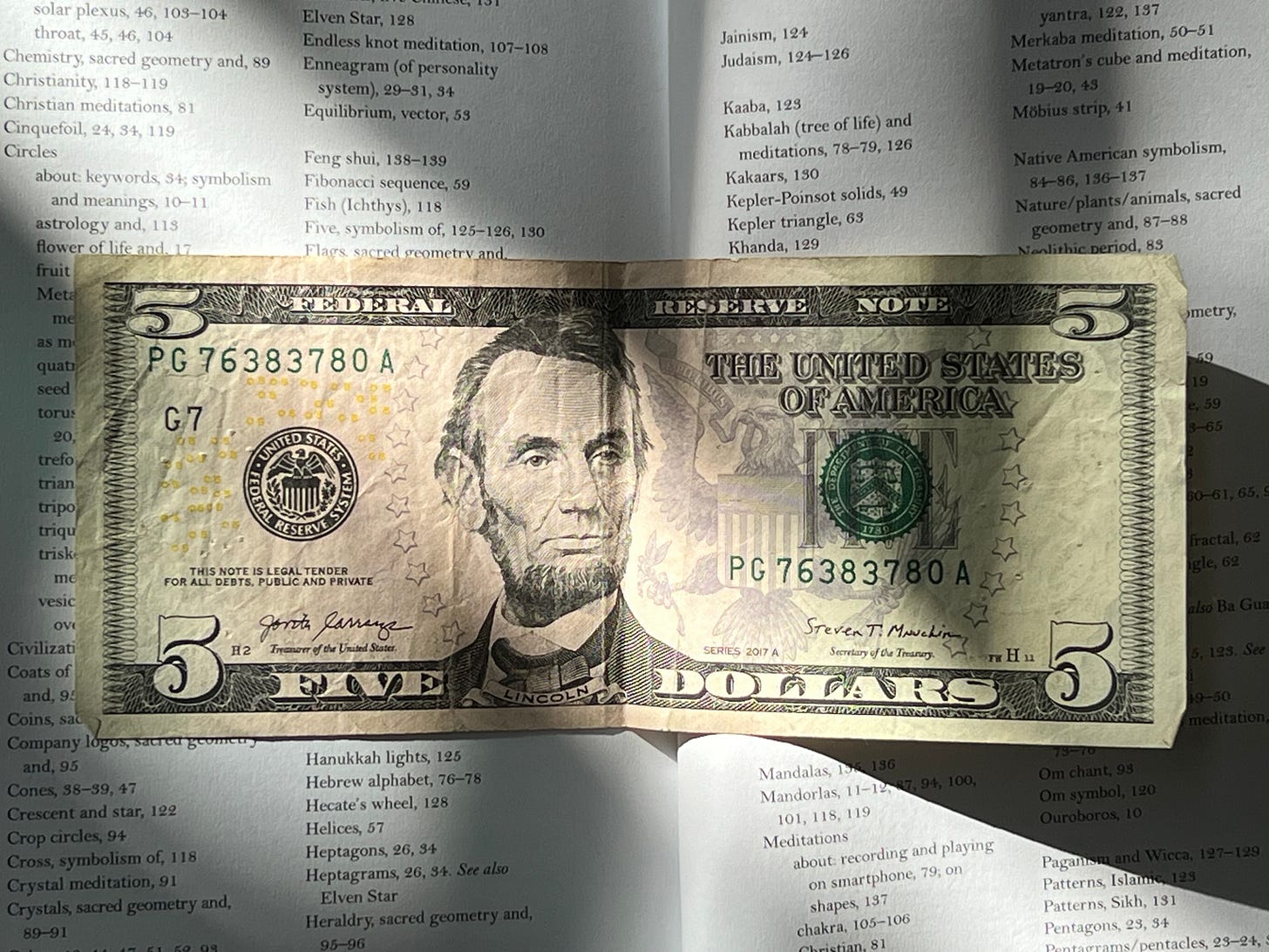 a five dollar bill covering a book about sacred geometry a five dollar bill covering a book about sacred geometry