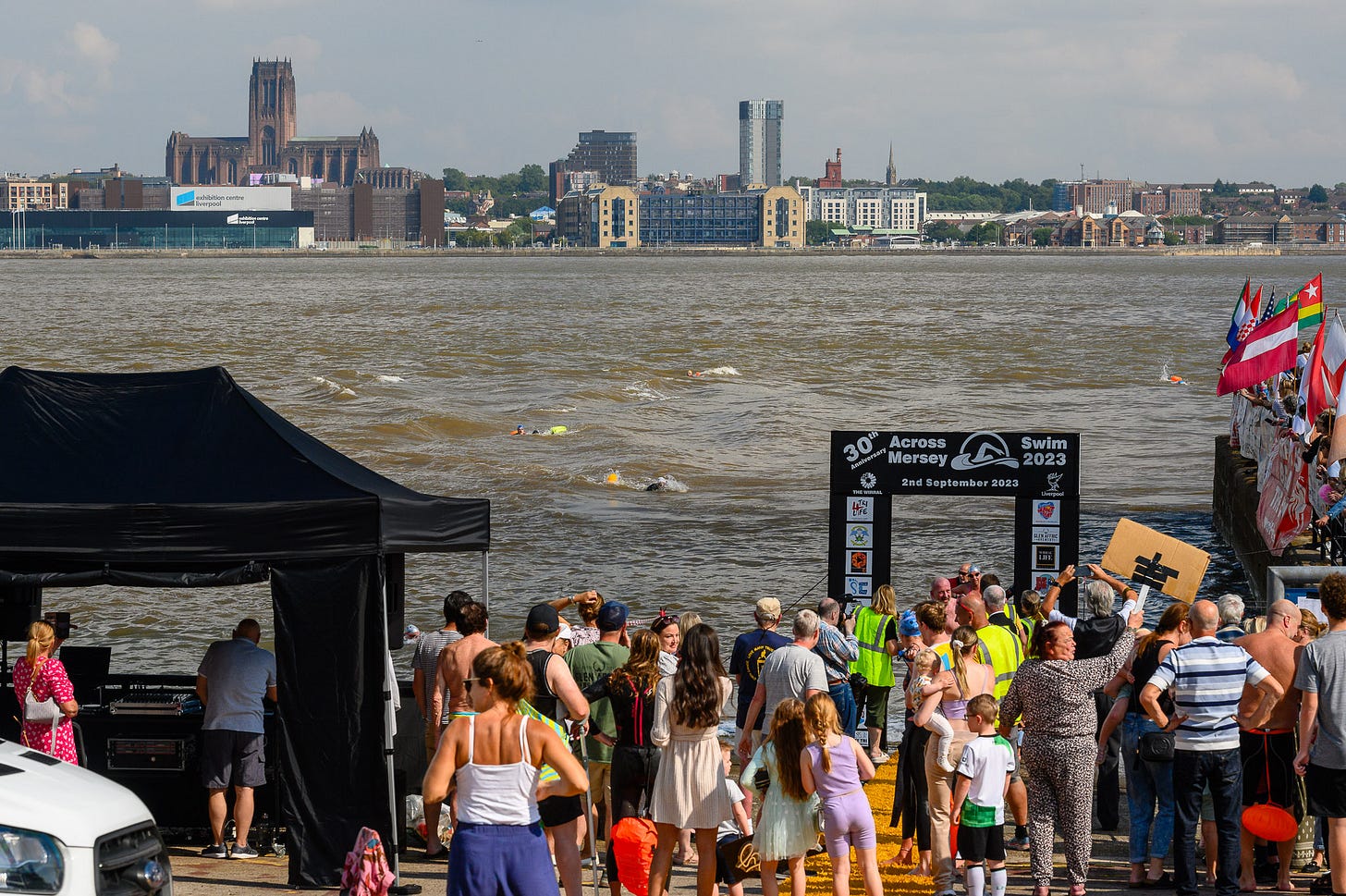 People battle against the currents in the River Mersey to swim back to shore.
