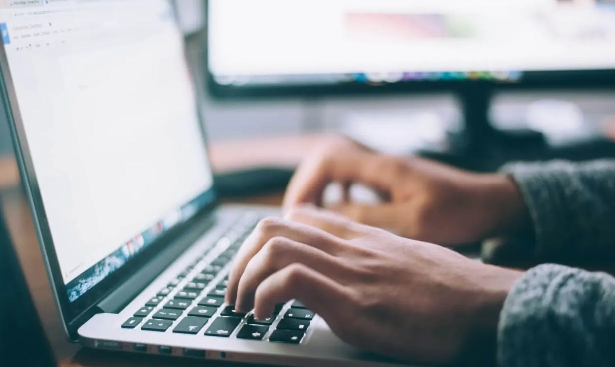 An almost empty fridge containing just a bottle of fizz and a red cabbage