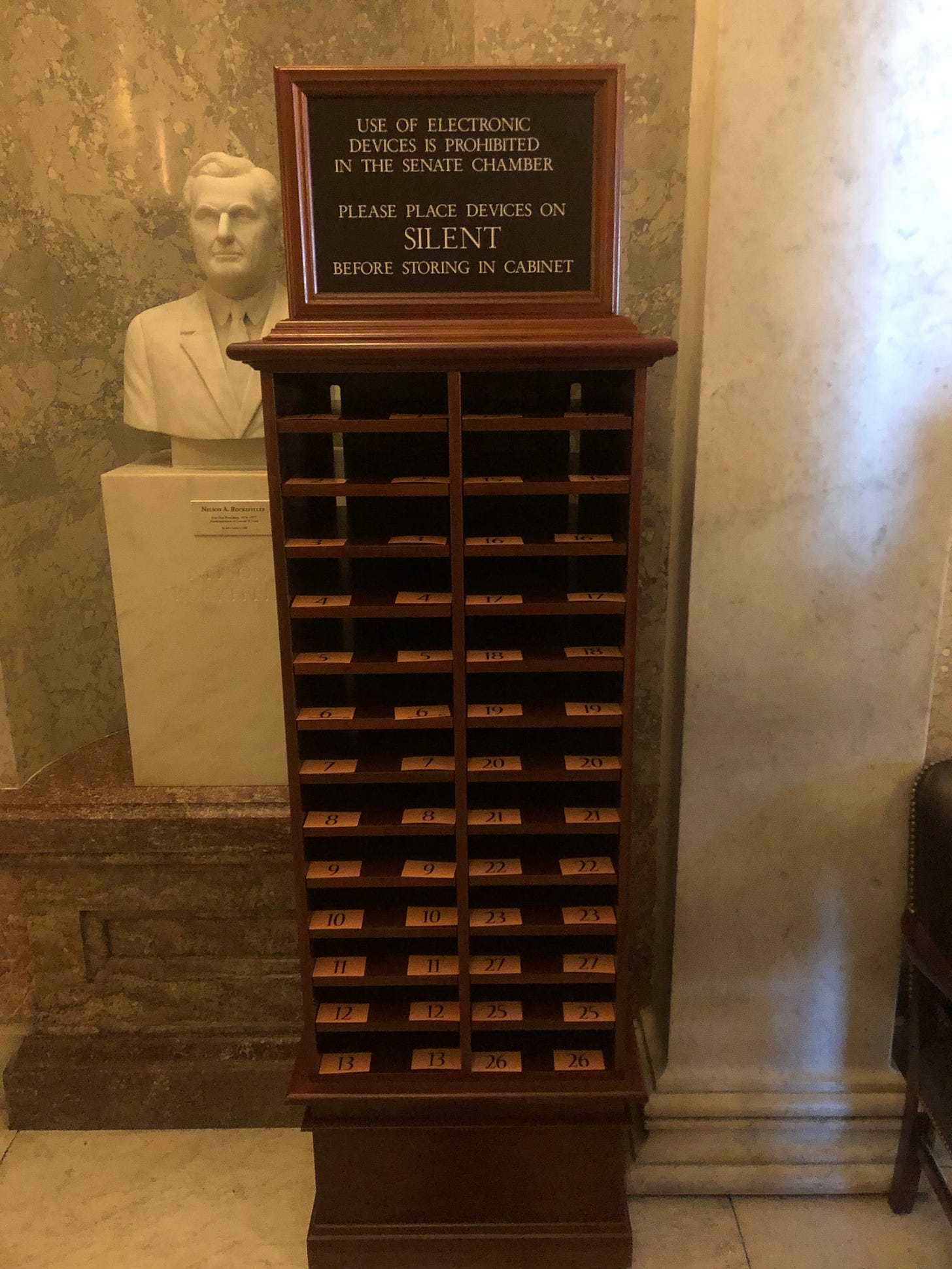 A sign over a wooden cubby warns US Senators to surrender all their electronics before entering the Senate chamber for Trump's impeachment trial A sign over a wooden cubby warns US Senators to surrender all their electronics before entering the Senate chamber for Trump's impeachment trial