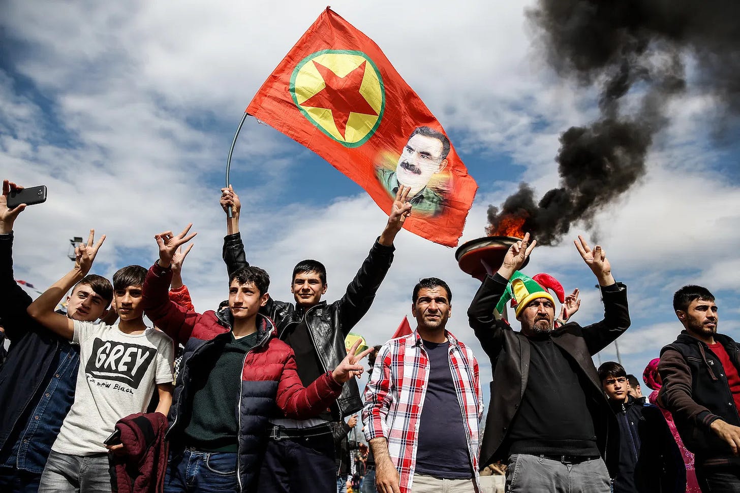 Kurdish men hold up a flag with a picture of jailed PKK leader Abdullah Ocalan.