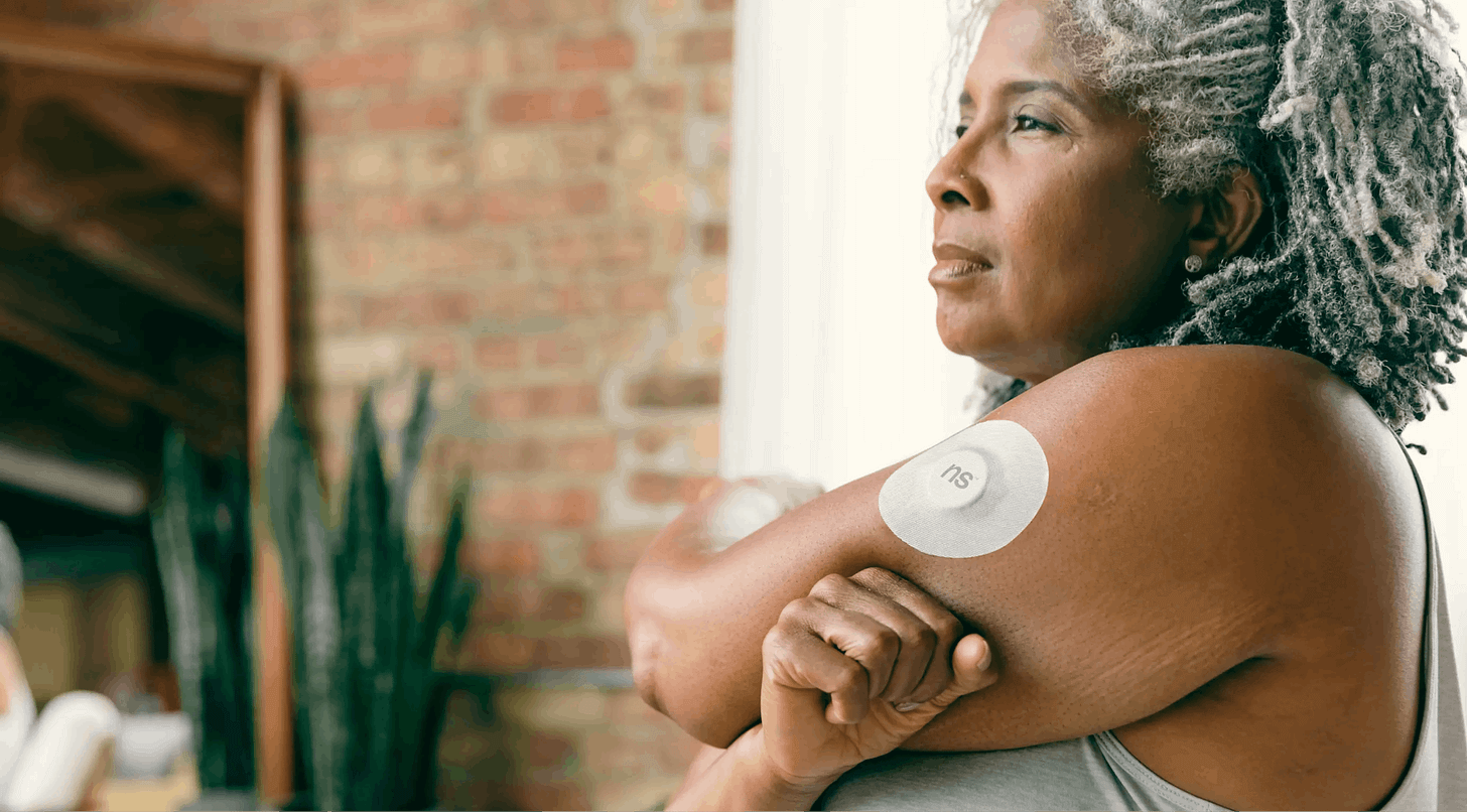 woman with diabetes wearing a cgm device on her arm