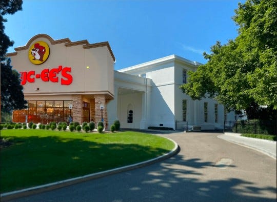 McDonalds restaurant exterior with golden arches logo and red lettering on a beige building featuring white columns and a portico mimicking the White House architecture set against a blue sky with green trees and manicured lawn in the foreground