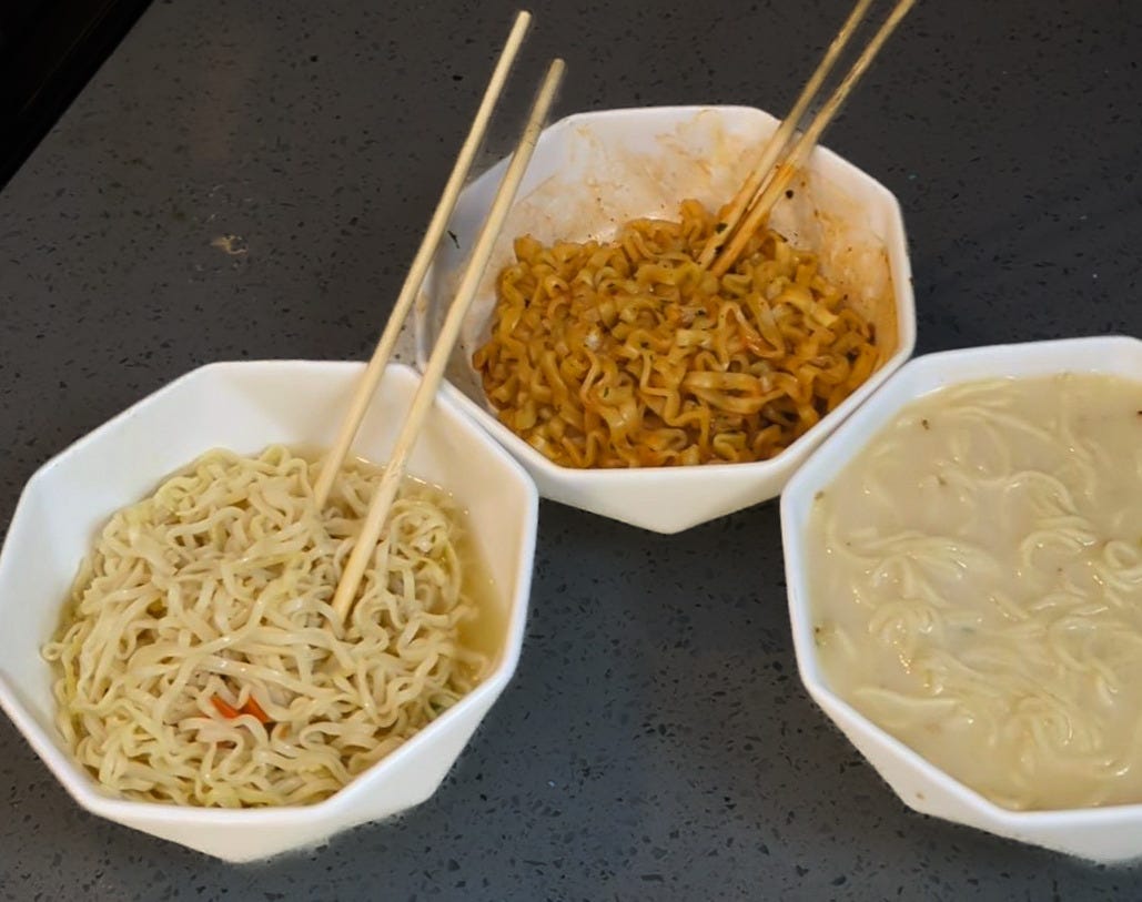 Three steaming ramen bowls in a row. Top Ramen, classic squiggly noodles in clear broth. Buldak Ramen with its signature glossy red sauce. Nissin Raoh, showing off its premium straight noodles in rich brown broth. Three steaming ramen bowls in a row. Top Ramen, classic squiggly noodles in clear broth. Buldak Ramen with its signature glossy red sauce. Nissin Raoh, showing off its premium straight noodles in rich brown broth.