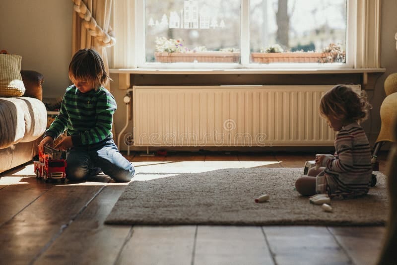 Netherlandian Kids on the Floor Playing Separately with Their Own Toys in a  Playroom Stock Photo - Image of carpet, small: 262078852