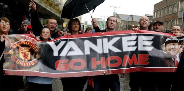 Manchester United fans holding a banner telling new American owner Malcolm Glazer to 'go home'. Manchester United fans holding a banner telling new American owner Malcolm Glazer to 'go home'.