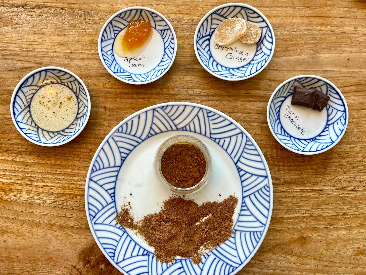 Blue and white plates with baharat, dark chocolate, crystallized ginger, apricot jam and rose water.