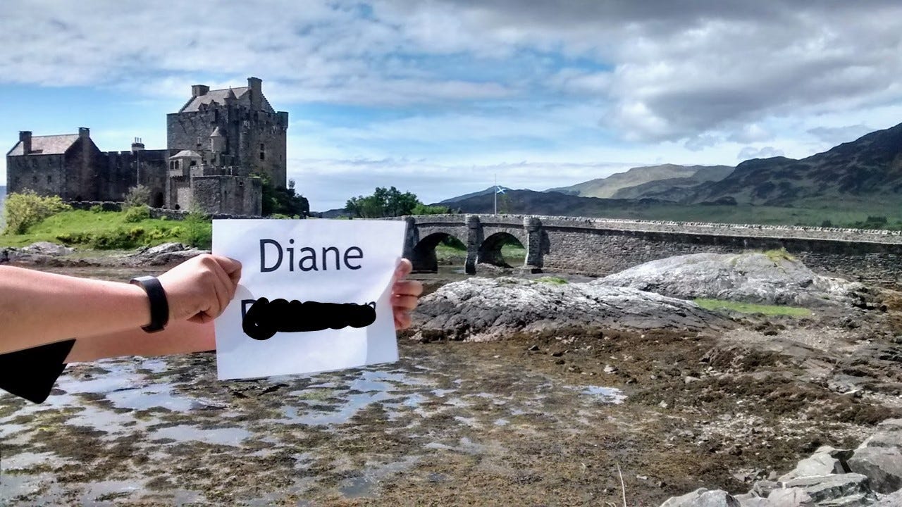 Arm holding out paper with name Diane and last name deleted, in front of castle with bridge