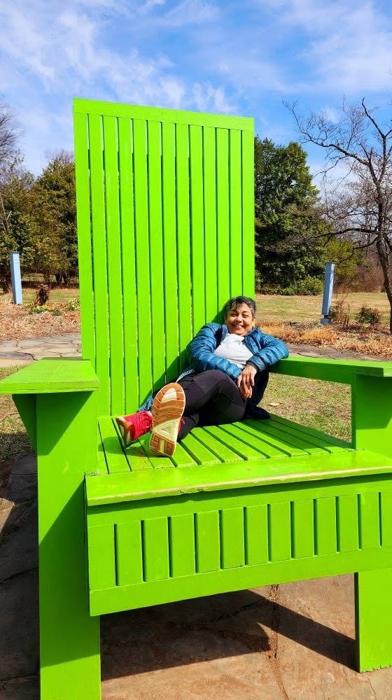 the author on a giant green Adirondack chair