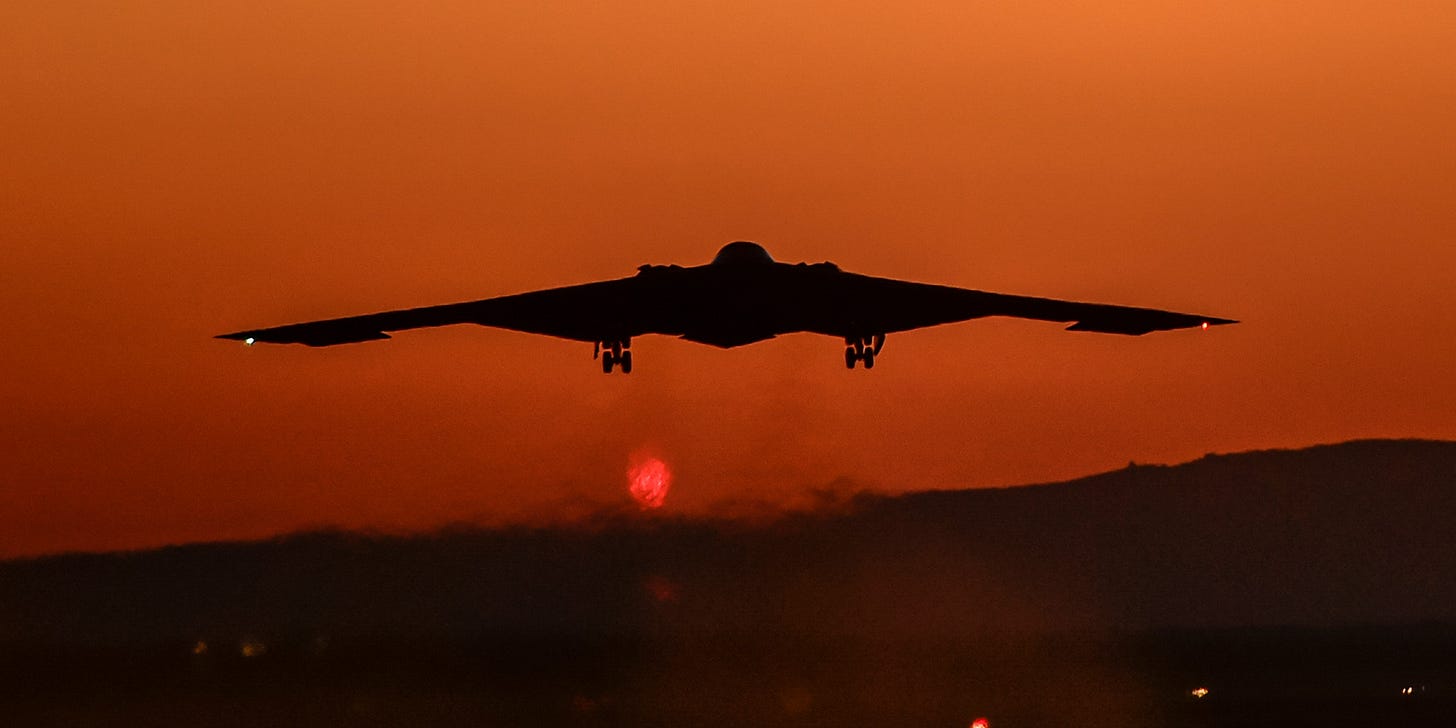 B2 bomber flying into sunset.