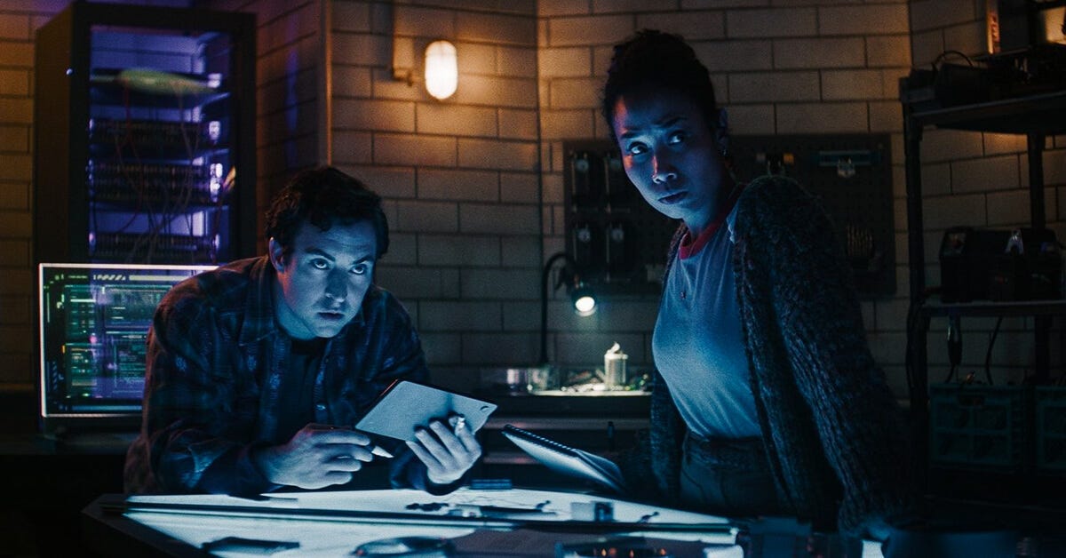 The engineers peer over in concern uplit by a schematics light table. The engineers peer over in concern uplit by a schematics light table.
