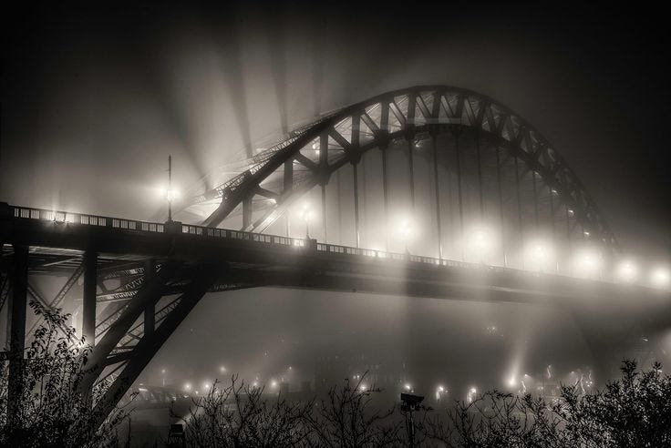 This may contain: the sydney harbour bridge is lit up at night in black and white, with fog This may contain: the sydney harbour bridge is lit up at night in black and white, with fog