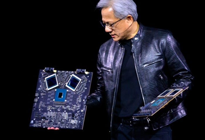 Jensen Huang showing off Nvidia computer chips on stage.