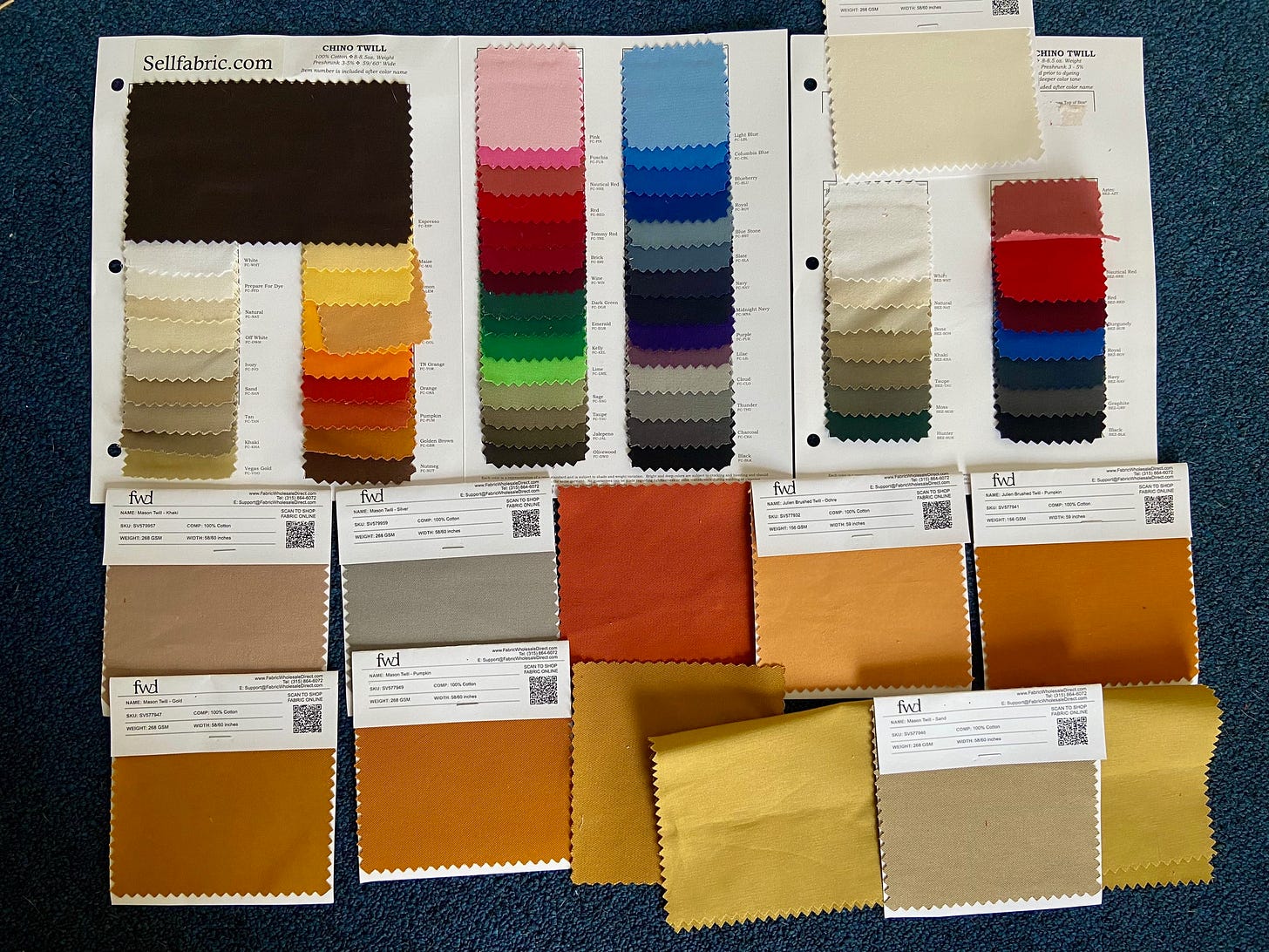 Fabric swatches in many different colors laid on a carpet