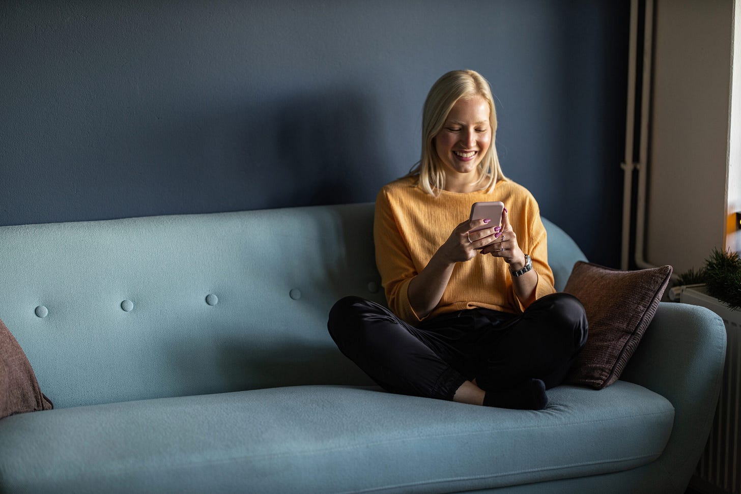 Two people using a phone on a couch in a Microsoft Source Asia article about Commonwealth Bank customer service AI Two people using a phone on a couch in a Microsoft Source Asia article about Commonwealth Bank customer service AI