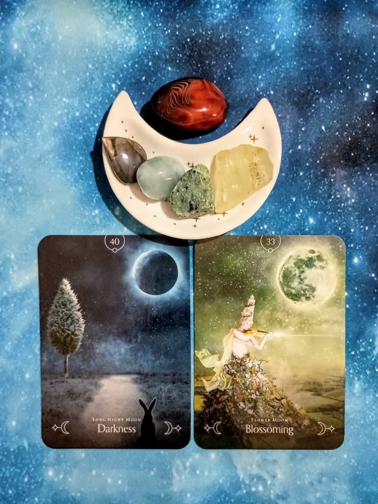 New Beginnings, New Energy: A Message From the Universe, 2 Queen of the Moon Oracle cards and crystals on a starry blue background