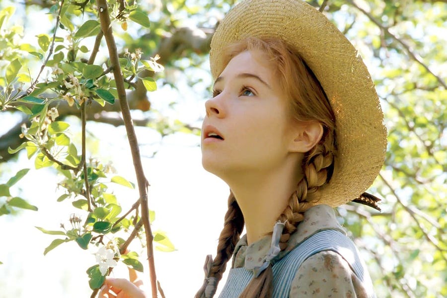 Actor Megan Follows as Anne Shirley looks up dreamily amongst the boughs of a tree - from the 1985 film version of Anne of Green Gables by Sullivan Entertainment