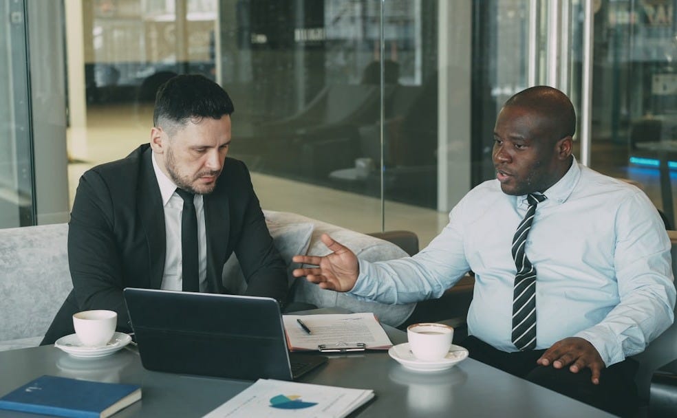 Two businessmen discussing a project at a table.