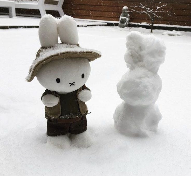 This may contain: there is a snowman and a bunny in the snow