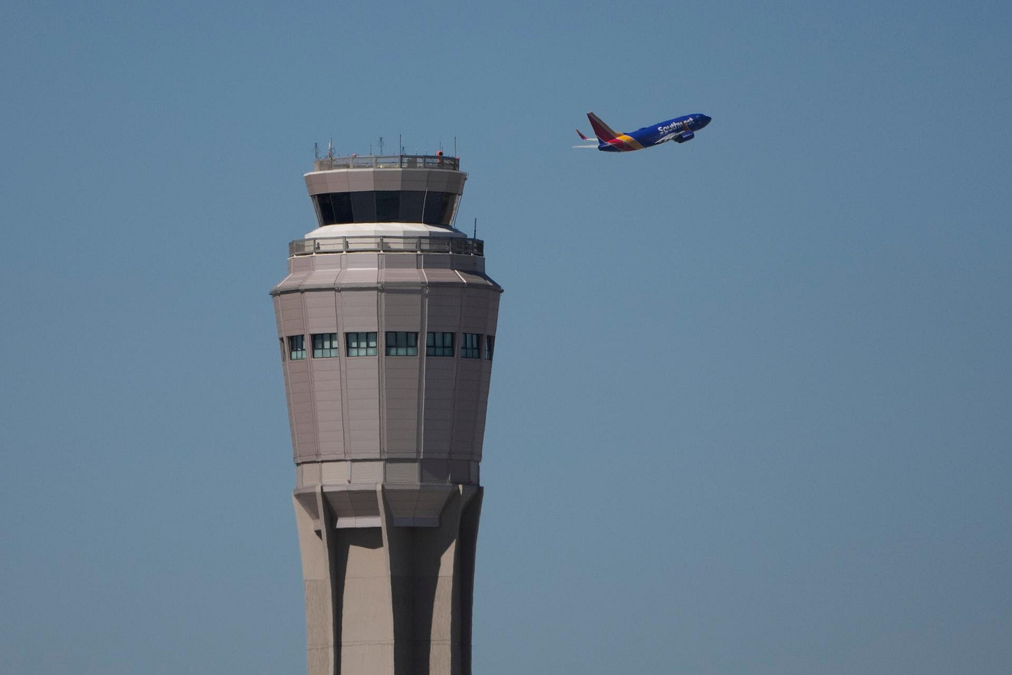 A plane takes off near the air traffic control tower at Harry Reid International Airport, Tuesday, in Las Vegas.