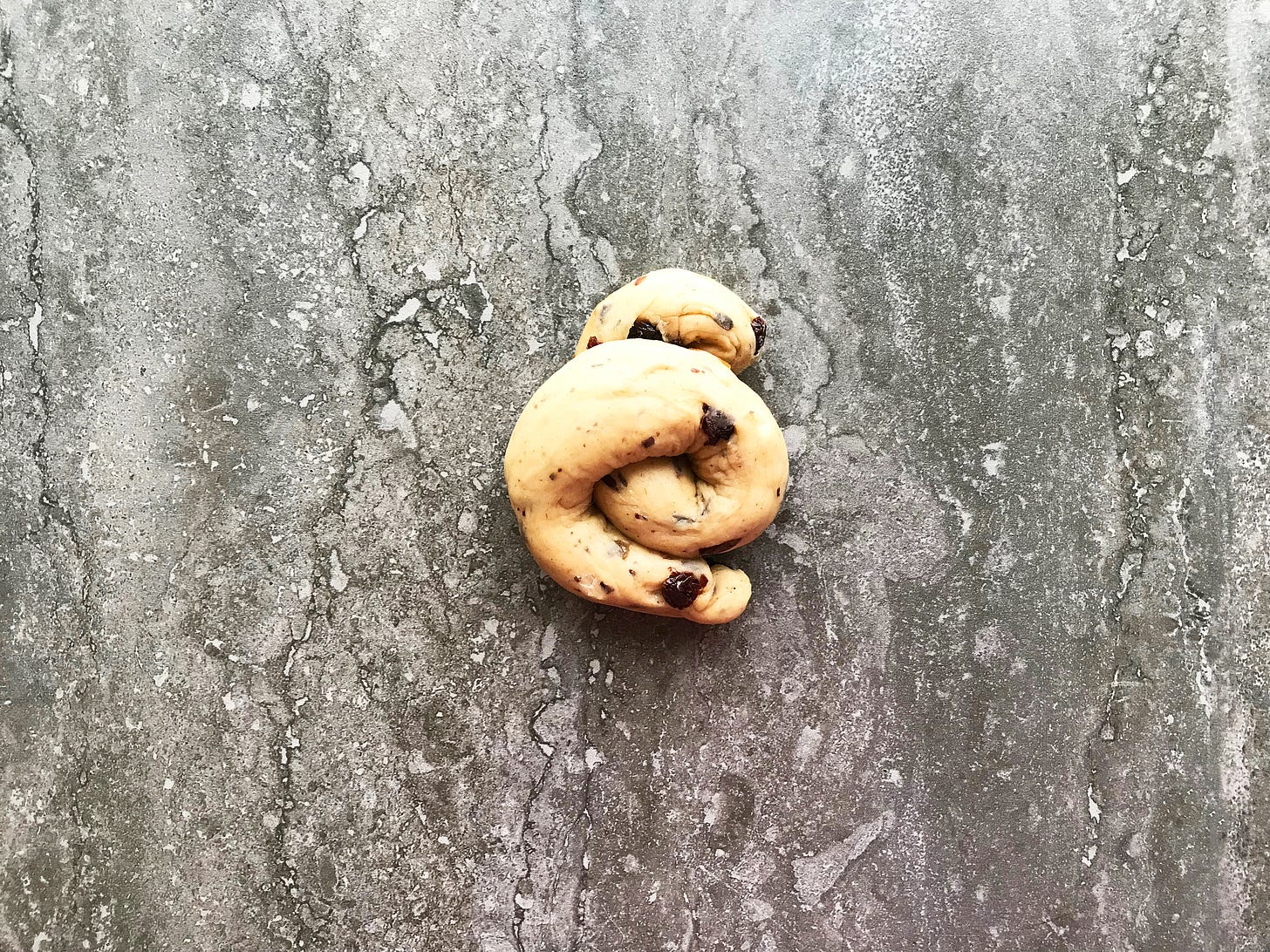 A twist of currant- and mixed peel-speckled hot cross bun dough. It kind of looks like a piggy's corkscrewed tail