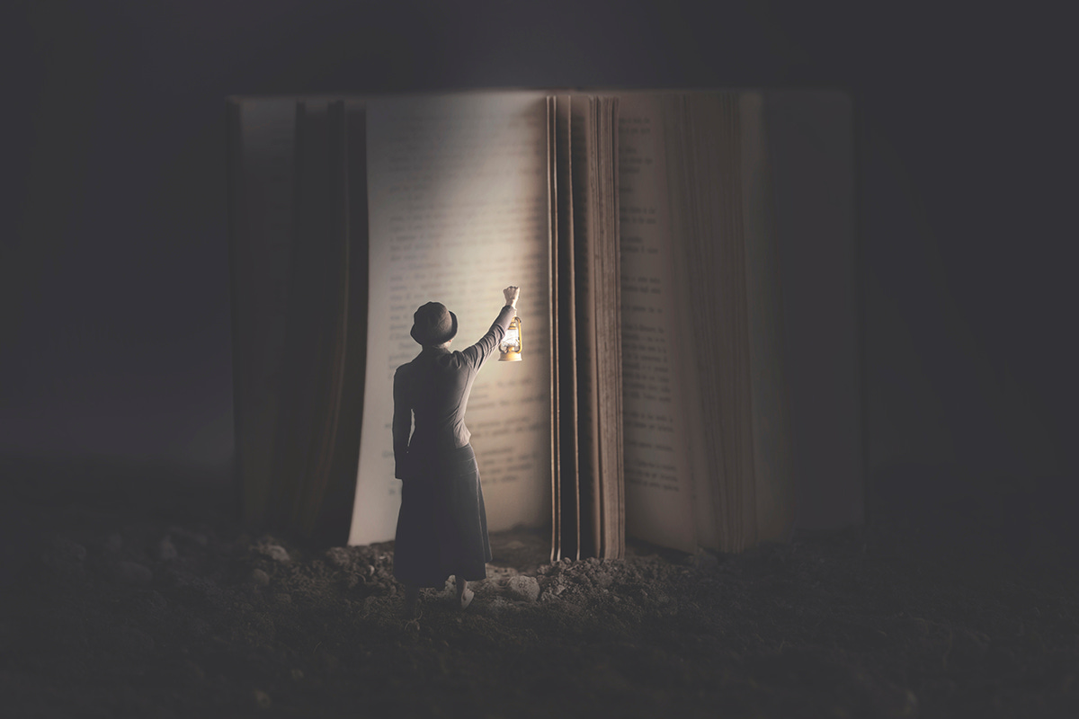 Woman Holding Lamp up to Illuminate Giant Book Woman Holding Lamp up to Illuminate Giant Book