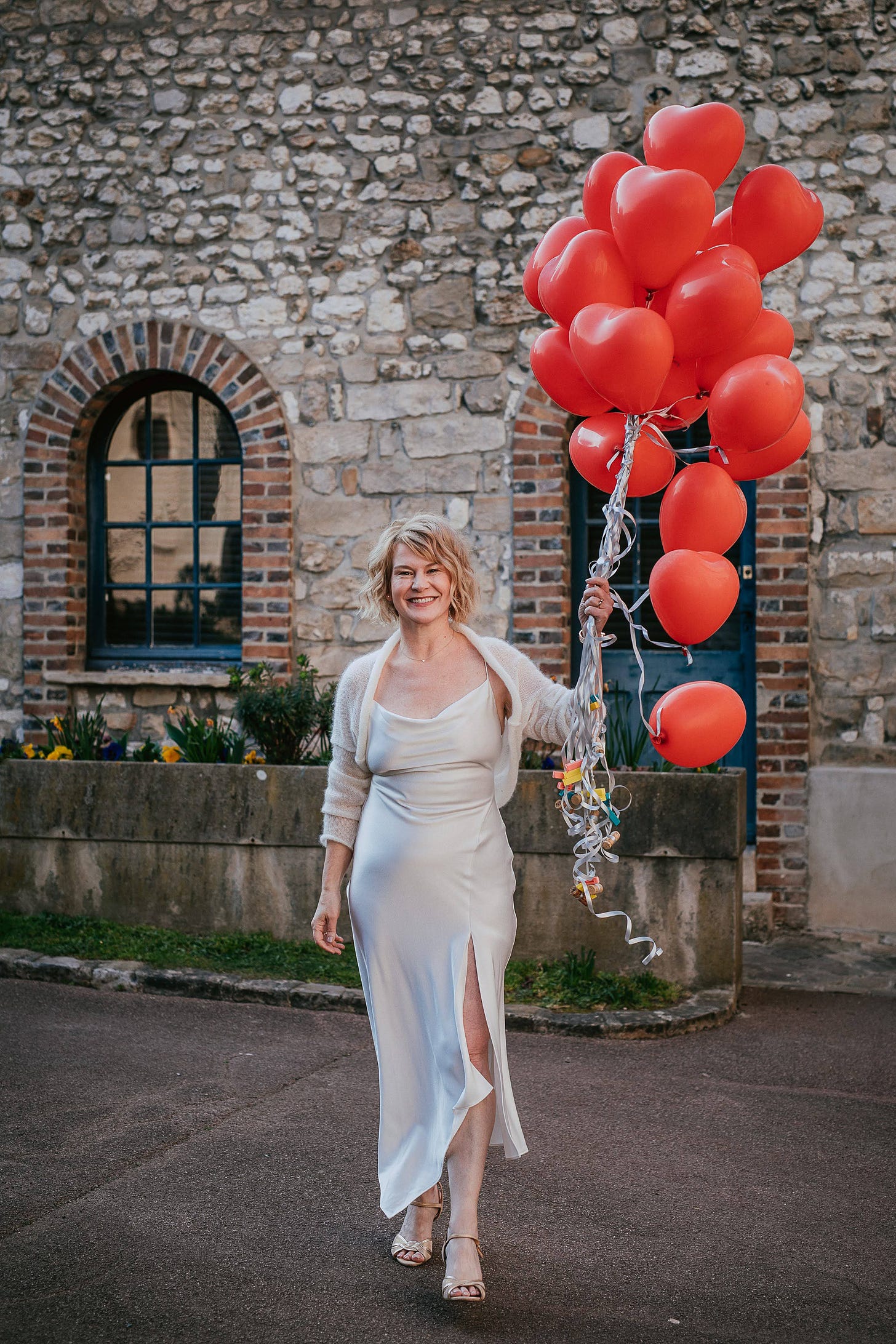 A bride poses with a balloon bouquet at her wedding A bride poses with a balloon bouquet at her wedding