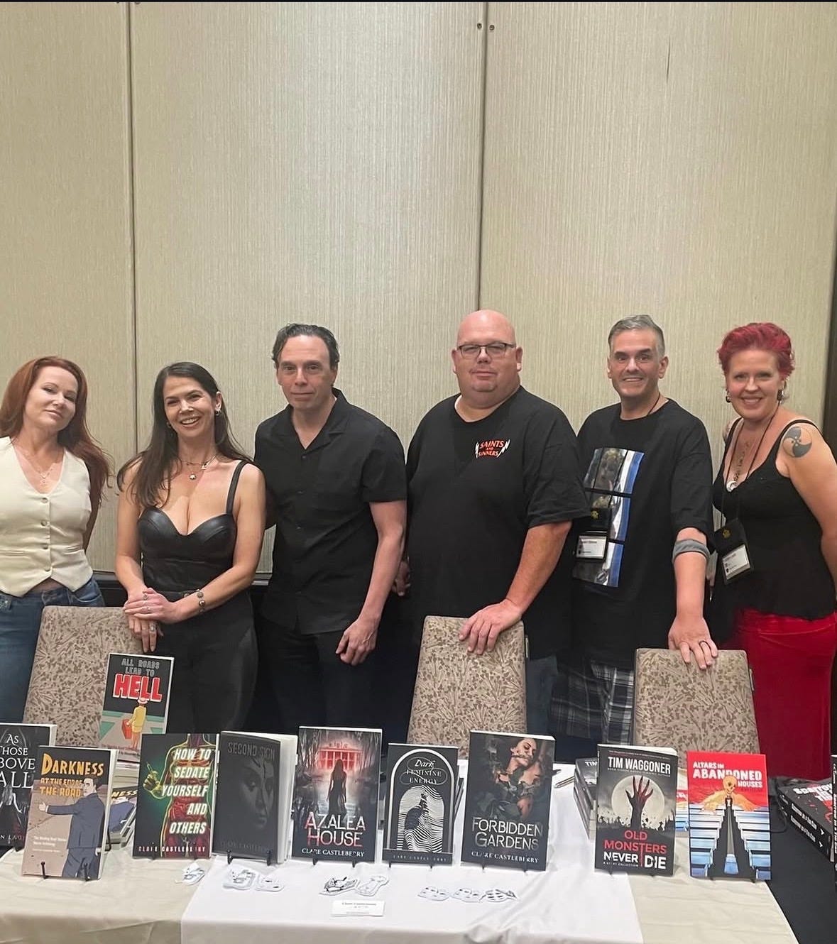 Six authors with books in front of them