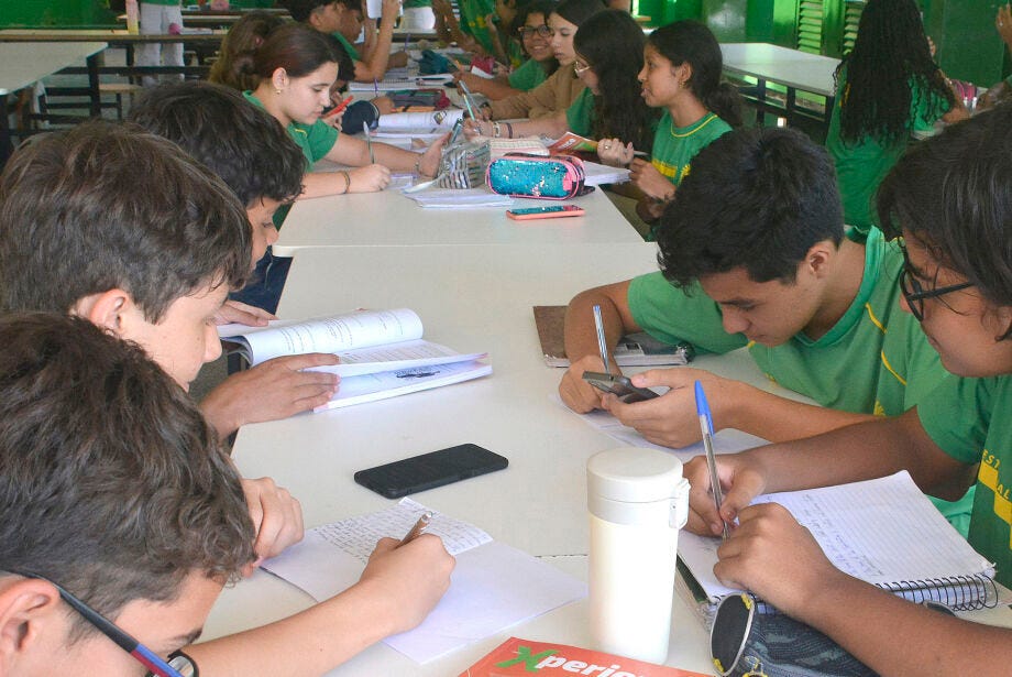 Photo of high schools students in a Brazilian classroom with cellphones on the table as they study.