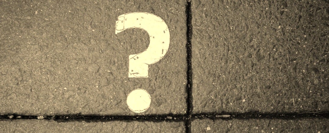 White question mark painted on concrete pavement White question mark painted on concrete pavement