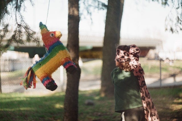 young blindfolded girl ready to strike a piñata