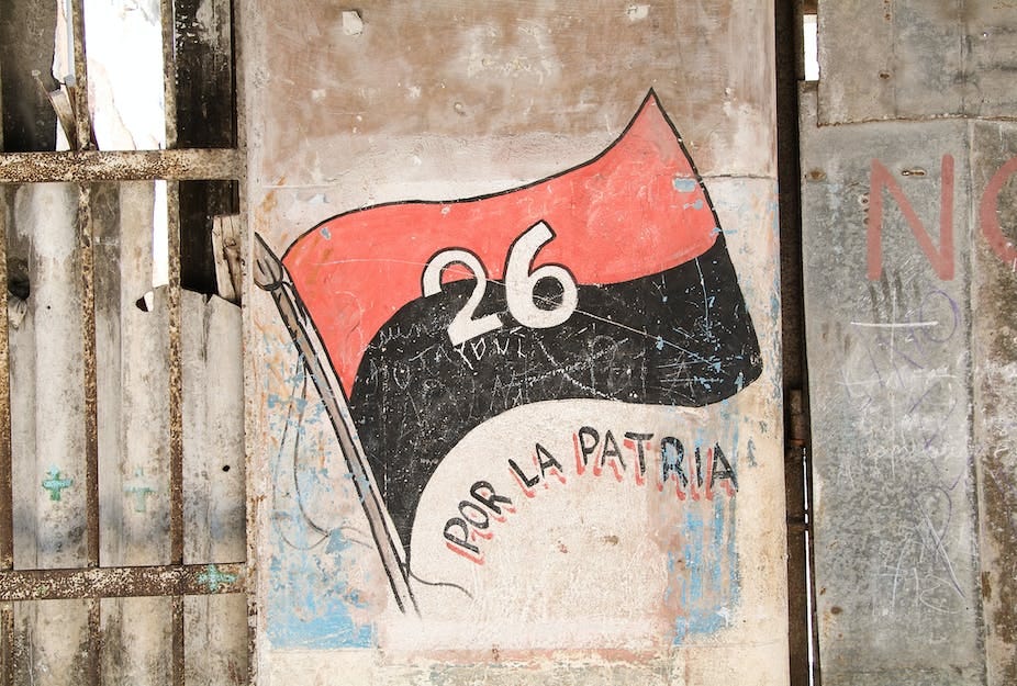 A flag consisting of a red strip and black strip and the white number 26 painted onto the side of a house. A flag consisting of a red strip and black strip and the white number 26 painted onto the side of a house.