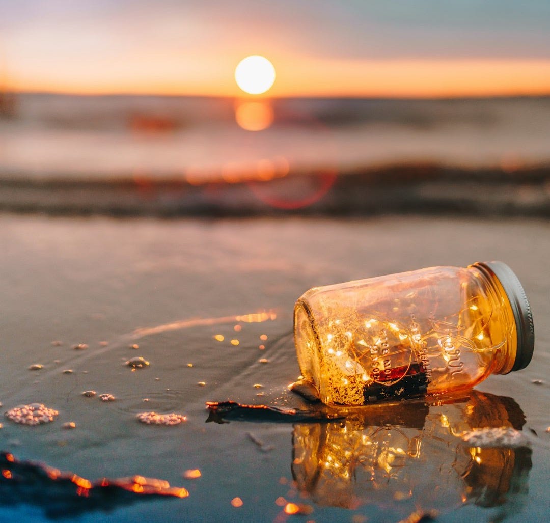 clear glass mason jar on beach during sunset
