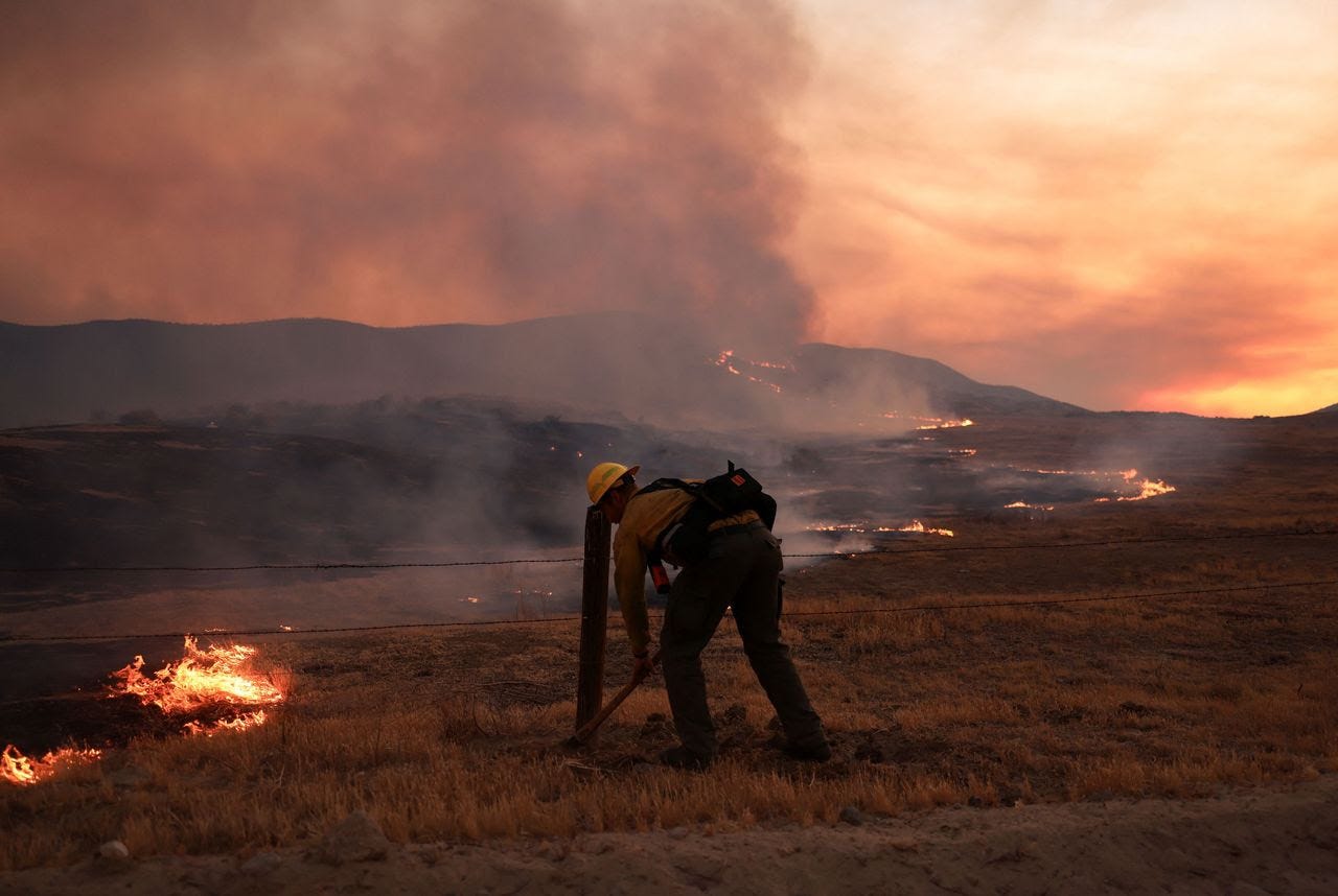 A firefighter works to tackle the Madre Fire yesterday near New Cuyama, California. (David Swanson/Reuters)