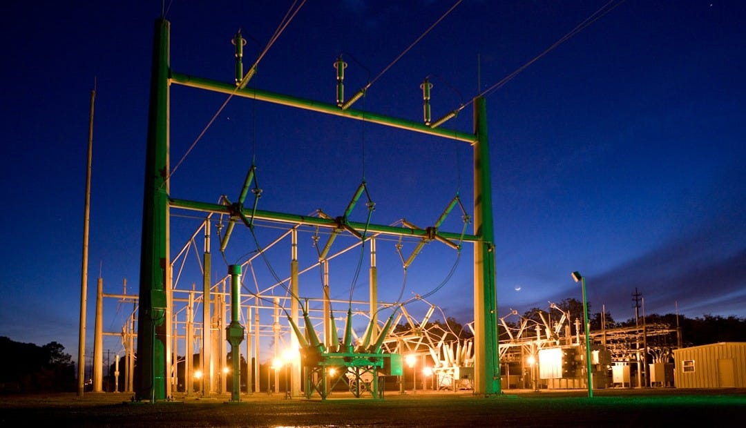 green and grey transmission tower during nighttime