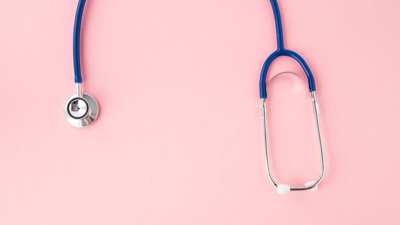 Blue stethoscope on a soft pink background