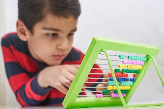 Boy focused on working with an abacus. Boy focused on working with an abacus.