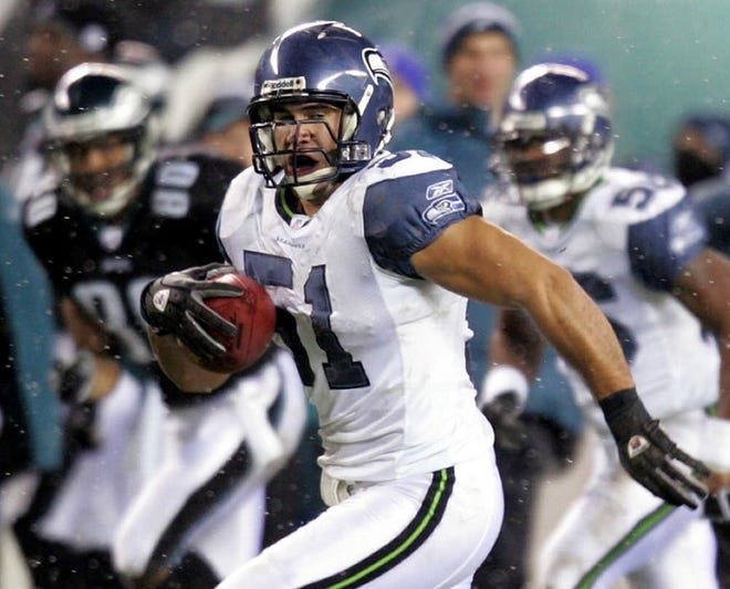Seattle’s Lofa Tatupu heads for a touchdown after an interception against Eagles QB Mike McMahon in the second quarter last night.