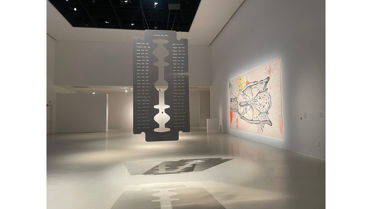 A flat, clydesdale-sized box cutter hangs from the ceiling of an art gallery, creating dramatic shadows on the floor. The metal has been inscribed with names and dates. A flat, clydesdale-sized box cutter hangs from the ceiling of an art gallery, creating dramatic shadows on the floor. The metal has been inscribed with names and dates.