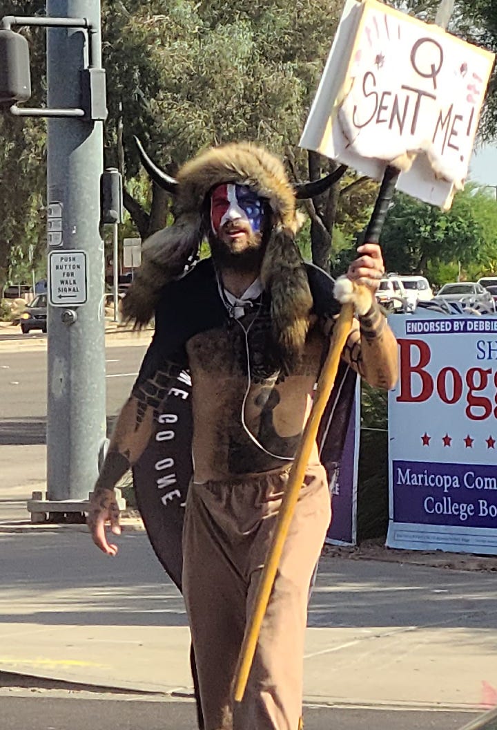 Jake Angeli waving a QAnon sign Jake Angeli waving a QAnon sign