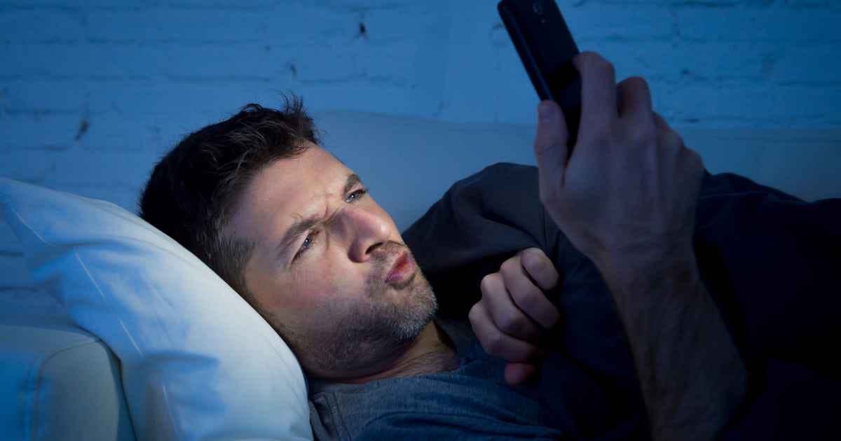 Man lay on the couch watching online porn on his phone
