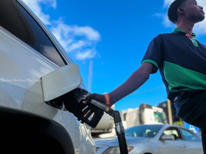An attendant fill a car tank with petrol