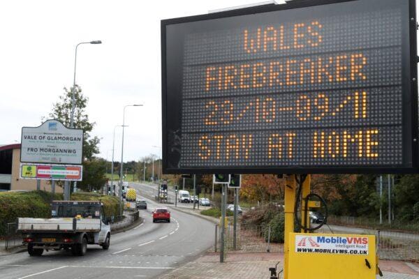 Traffic passes a COVID-19 sign informing drivers of the "firebreak" lockdown on Oct. 23, 2020 in Cardiff. (Geoff Caddick/AFP via Getty Images) Traffic passes a COVID-19 sign informing drivers of the "firebreak" lockdown on Oct. 23, 2020 in Cardiff. (Geoff Caddick/AFP via Getty Images)