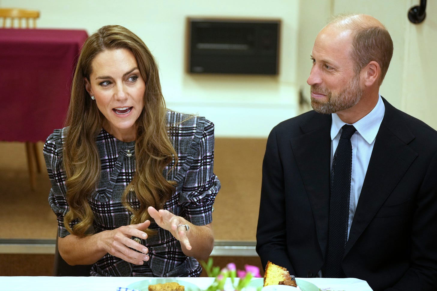 Princess Kate explaining something while Prince William watches Princess Kate explaining something while Prince William watches