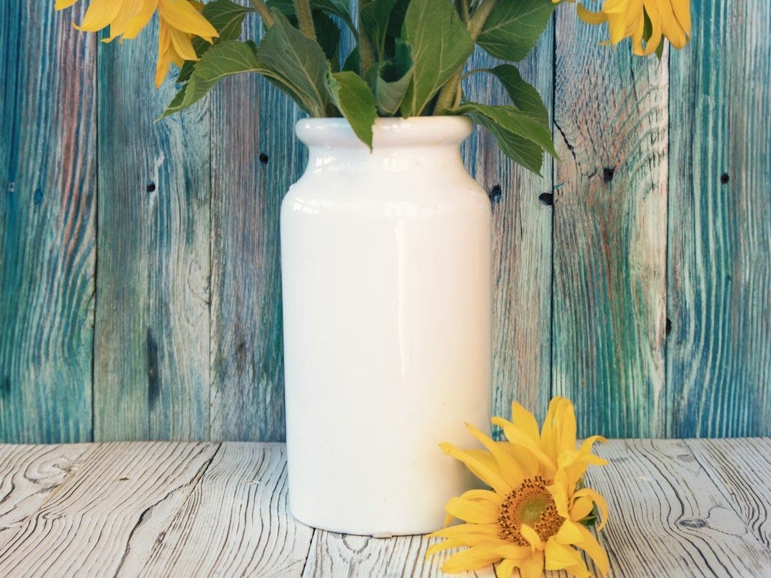 yellow sunflower in white ceramic vase yellow sunflower in white ceramic vase