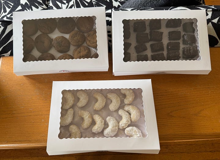 One image ofnthe author holding three white cardboard boxes of cookies, and another i age showing the cookies through clear lids