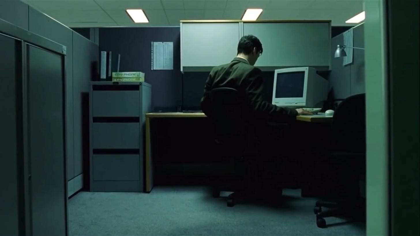 In the lower left hand corner of this Matrix scene, a persons hand and  wristwatch can be seen on the table behind Neo and a worker, despite them  being the only two people in the room.