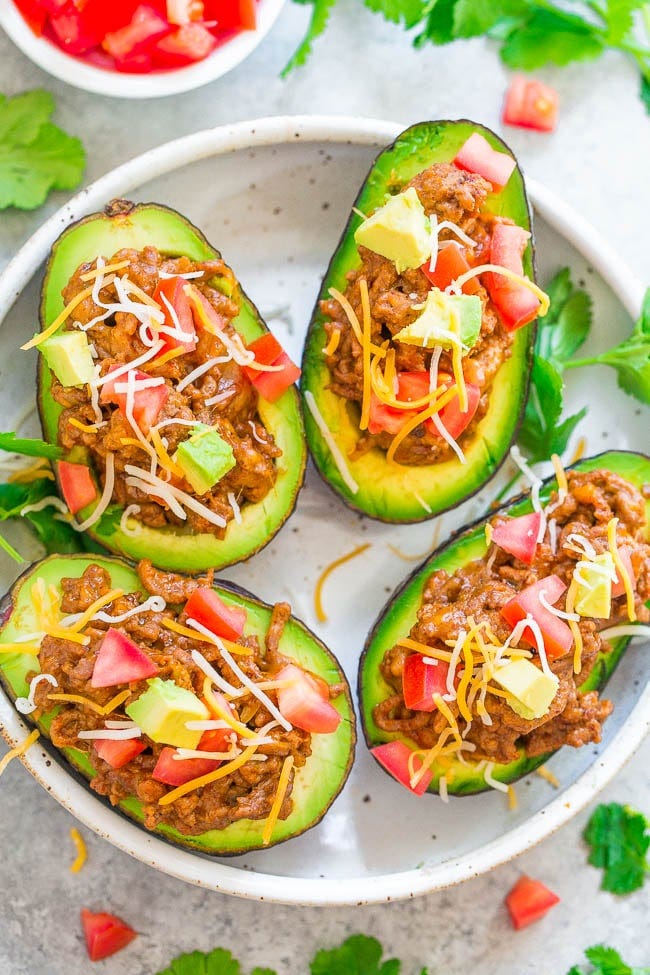 Taco Stuffed Avocados - Like avocados? Then you are going to LOVE these taco STUFFED avocados with ground beef, CHEESE, and more!! EASY, ready in 15 minutes, a family favorite, and perfect for busy weeknights!!