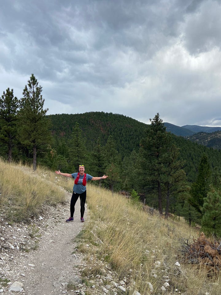Meg Smith stands on a trail in Montana Mountains on a run.